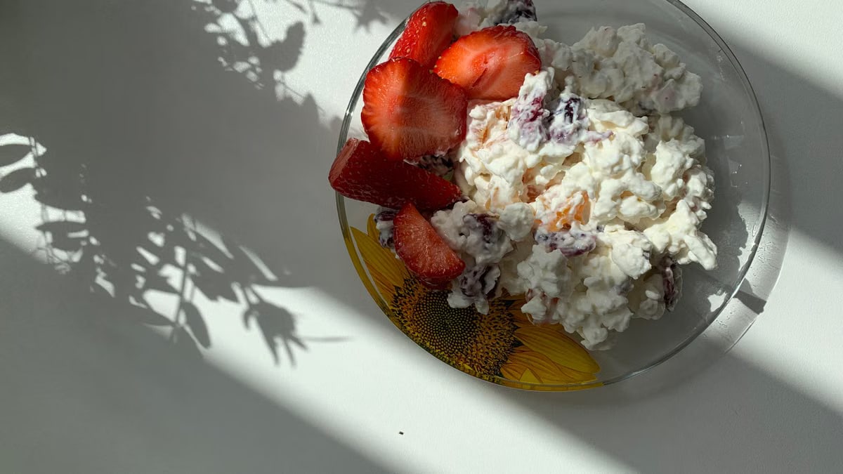 A sunlit plate of strawberries and cottage cheese perfect for breakfast.
